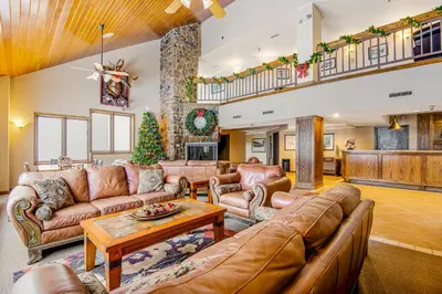a living room with leather furniture and a christmas tree at Iron Horse Resort 3063 in Winter Park
