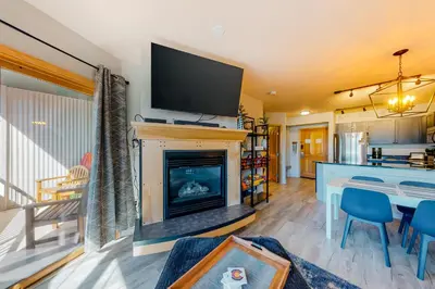 a living room with a fireplace with a flat screen tv at Silvermill Lodge 8285 in Keystone