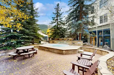 a patio with a hot tub and two picnic tables at Silvermill Lodge 8295 in Keystone