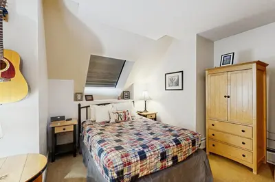 a bedroom with a bed and a dresser and a guitar at Silvermill Lodge 8295 in Keystone