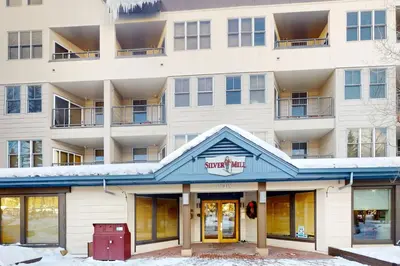 an apartment building with snow on the ground at Silvermill Lodge 8202 in Keystone