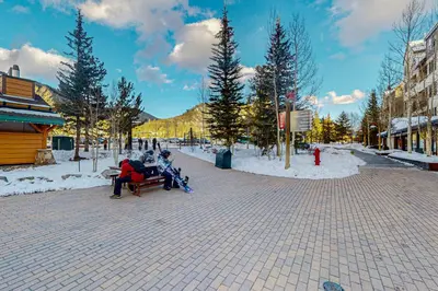 a group of people sitting on a bench in the snow at Silvermill Lodge 8202 in Keystone