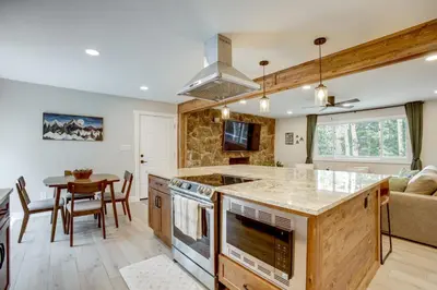 a kitchen and living room with a table and a couch at Hot Tub and Game Room Peaceful Retreat in Evergreen in Evergreen
