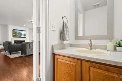 a bathroom with a sink and a living room at Spacious SIX Bedroom, Great Location in Longmont
