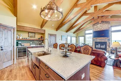 a kitchen with a large island and a living room at New Mountain Home, Amazing Unobstructed Lake & Mountain Views, Hot Tub, Close to Town! in Grand Lake