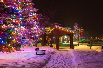 a christmas tree in front of a building with christmas lights at New Mountain Home, Amazing Unobstructed Lake & Mountain Views, Hot Tub, Close to Town! in Grand Lake