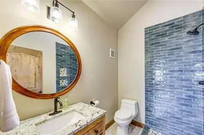 a bathroom with a sink and a mirror and a toilet at New Mountain Home, Amazing Unobstructed Lake & Mountain Views, Hot Tub, Close to Town! in Grand Lake