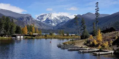 a group of boats on a lake with a snow covered mountain at New Mountain Home, Amazing Unobstructed Lake & Mountain Views, Hot Tub, Close to Town! in Grand Lake
