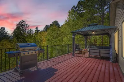 a deck with a grill and a gazebo at RollinsVilla home in Rollinsville