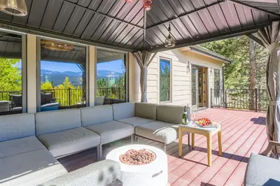 a screened in porch with a couch and a table at RollinsVilla home in Rollinsville
