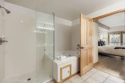a bathroom with a tub and a glass shower at 5094 Gateway condo in Keystone