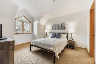 a white bedroom with a bed and a window at 5094 Gateway condo in Keystone