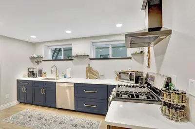 a kitchen with blue cabinets and a stove top oven at Modern Comfort in Historic Denver in Denver