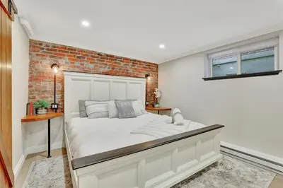 a white bed in a room with a brick wall at Modern Comfort in Historic Denver in Denver