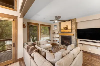 a living room with a large couch and a fireplace at Seasons at Keystone 1893 in Keystone