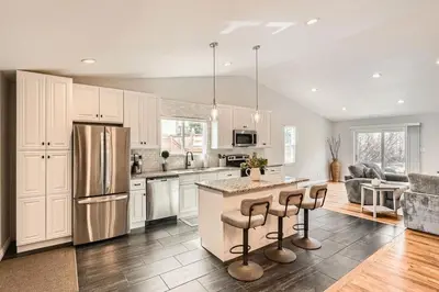 a kitchen with white cabinets and a island with bar stools at Littleton DTC updated GEM with Hot Tub! in Centennial