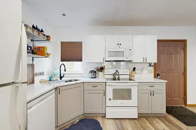 a kitchen with white cabinets and white appliances at Mountainside 049 in Granby