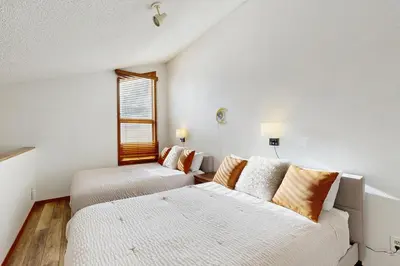 a white room with two beds and a window at Mountainside 049 in Granby
