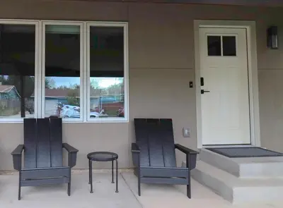 two chairs sitting in front of a house with a door at New cozy Fall foothill retreat in Boulder in Boulder