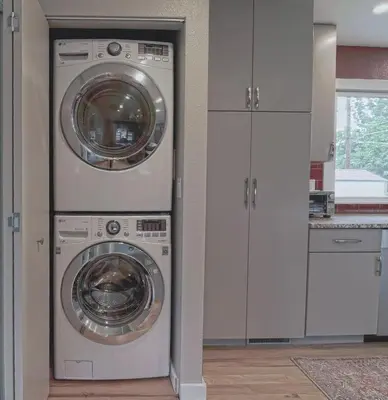 two washing machines in a kitchen with white cabinets at New cozy Fall foothill retreat in Boulder in Boulder
