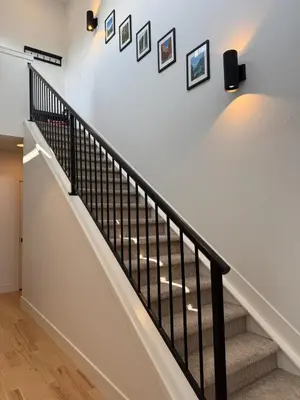a staircase with black railings and pictures on the wall at Cozy 3 Bedroom Denver Home by Mile High Stadium and Downtown! in Denver