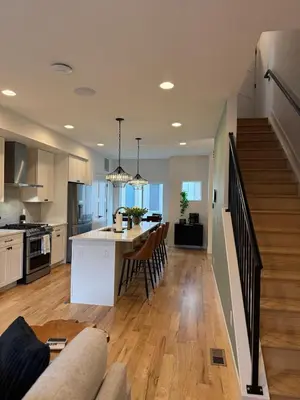 a kitchen and living room with a staircase and a living room at Cozy 3 Bedroom Denver Home by Mile High Stadium and Downtown! in Denver