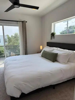 a bedroom with a large white bed with a ceiling fan at Cozy 3 Bedroom Denver Home by Mile High Stadium and Downtown! in Denver