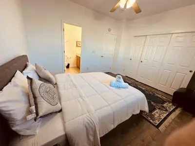 a bedroom with a large white bed with a stuffed animal on it at Cozy near airport vacation home Brighton in Brighton