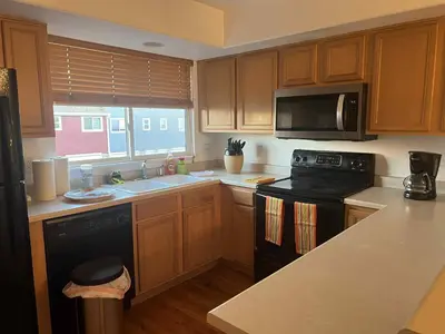 a kitchen with wooden cabinets and a black stove top oven at Cozy near airport vacation home Brighton in Brighton