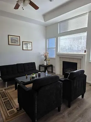 a living room with black furniture and a fireplace at Cozy near airport vacation home Brighton in Brighton