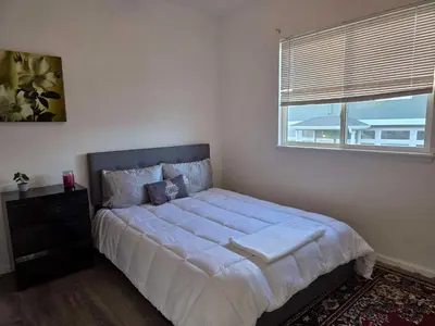 a bedroom with a large bed with a window at Cozy near airport vacation home Brighton in Brighton