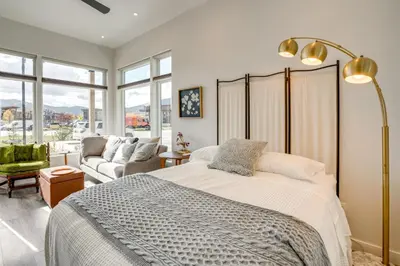 a bedroom with a bed and a couch and windows at Walk to Ski Shuttles and Stores! Modern Frisco Unit in Frisco