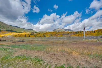 a field with a flag and mountains in the background at Walk to Ski Shuttles and Stores! Modern Frisco Unit in Frisco