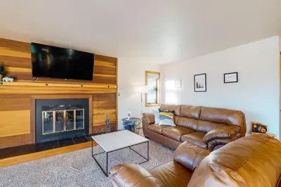 a living room with a leather couch and a fireplace at Timber Ridge 217 in Silverthorne