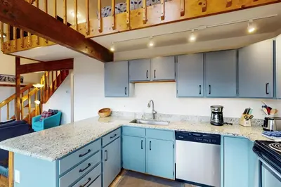 a kitchen with blue cabinets and a staircase at Buffalo Ridge C302 in Silverthorne