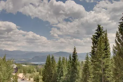 a group of trees on a hill with a cloudy sky at Buffalo Ridge C302 in Silverthorne