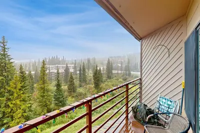 a balcony with a chair and a view of the forest at Buffalo Ridge C302 in Silverthorne