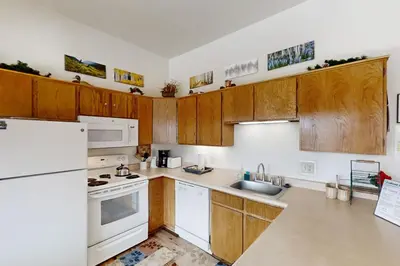 a kitchen with white appliances and wooden cabinets at Buffalo Ridge C101 in Silverthorne