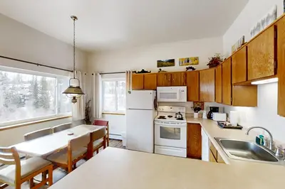 a kitchen with a white refrigerator and a table at Buffalo Ridge C101 in Silverthorne