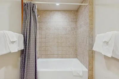 a bathroom with a tub and a shower with towels at Oro Grande 414 in Keystone