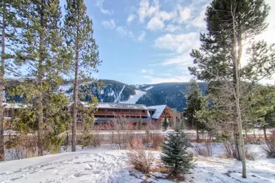 a building in the snow next to some trees at Oro Grande 414 in Keystone