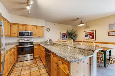 a kitchen with wooden cabinets and a large counter top at Tenderfoot Lodge 2663 in Keystone