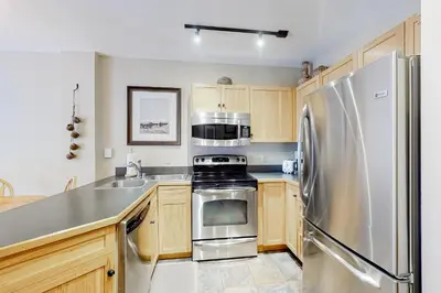 a kitchen with stainless steel appliances and wooden cabinets at Buffalo Lodge 8372 in Keystone