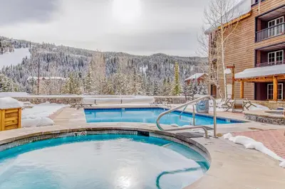 a swimming pool in front of a building with snow at Buffalo Lodge 8372 in Keystone