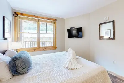 a bedroom with a large bed with a tv on the wall at Buffalo Lodge 8372 in Keystone