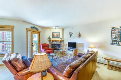 a living room with a leather couch and a television at Tenderfoot Lodge 2664 in Keystone