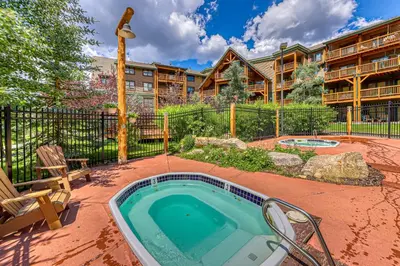 a hot tub in a yard with a building at Tenderfoot Lodge 2664 in Keystone