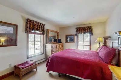 a bedroom with a large bed and two windows at Oro Grande 416 in Keystone