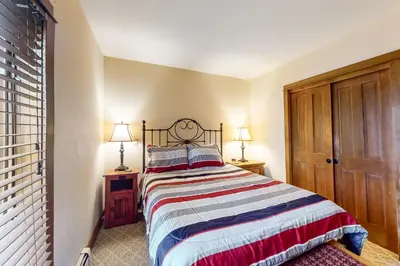 a bedroom with a bed with a striped blanket at Oro Grande 216 in Keystone