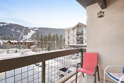 a red chair on a balcony with a mountain view at Oro Grande 216 in Keystone